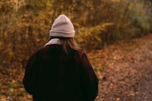 Back View of a Woman Wearing Jacket and Beanie Hat 