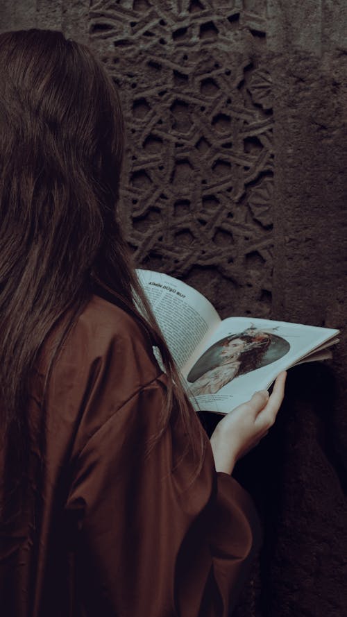 Back View of a Woman Reading a Magazine