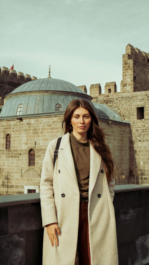 Beautiful Woman in a Trench Coat Posing Near Historical Building