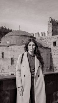 Black and white portrait of a woman at a historical site with a dome.