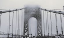 布鲁克林大桥笼罩在黑白雾气中，桥下车辆穿行，捕捉着城市氛围