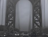 雾气弥漫的吊桥下，路灯旁停着车辆，营造出一幅喜怒无常的场景