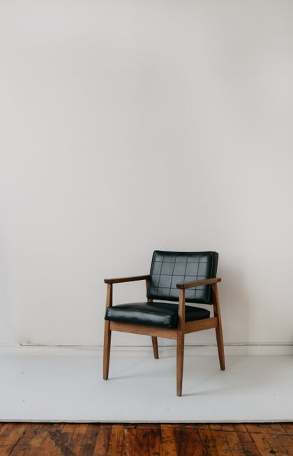 Vintage leather armchair against a plain wall, photo by Mathilde Langevin on Pexels