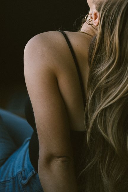 Artistic close-up of a woman's back with long blonde hair, showcasing elegance and style.