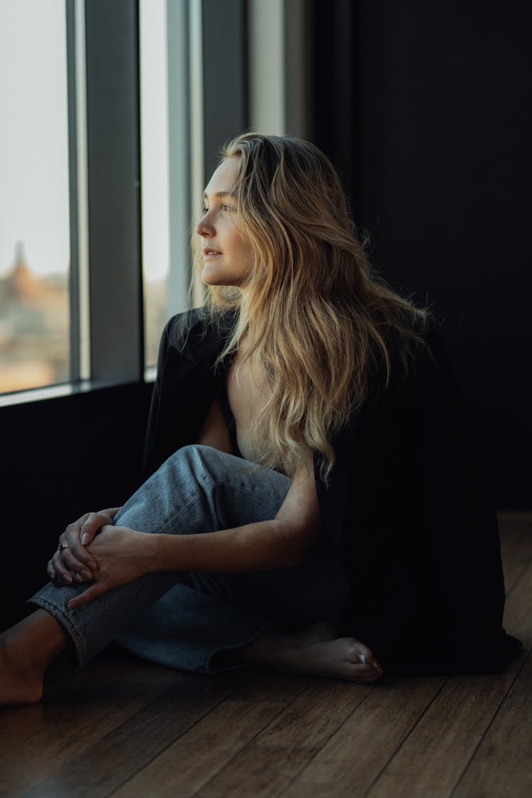 Blonde Woman Sitting On Floor Near Windows