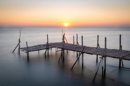 Captivating sunset over a wooden pier on a tranquil Thai seascape, offering a peaceful retreat.
