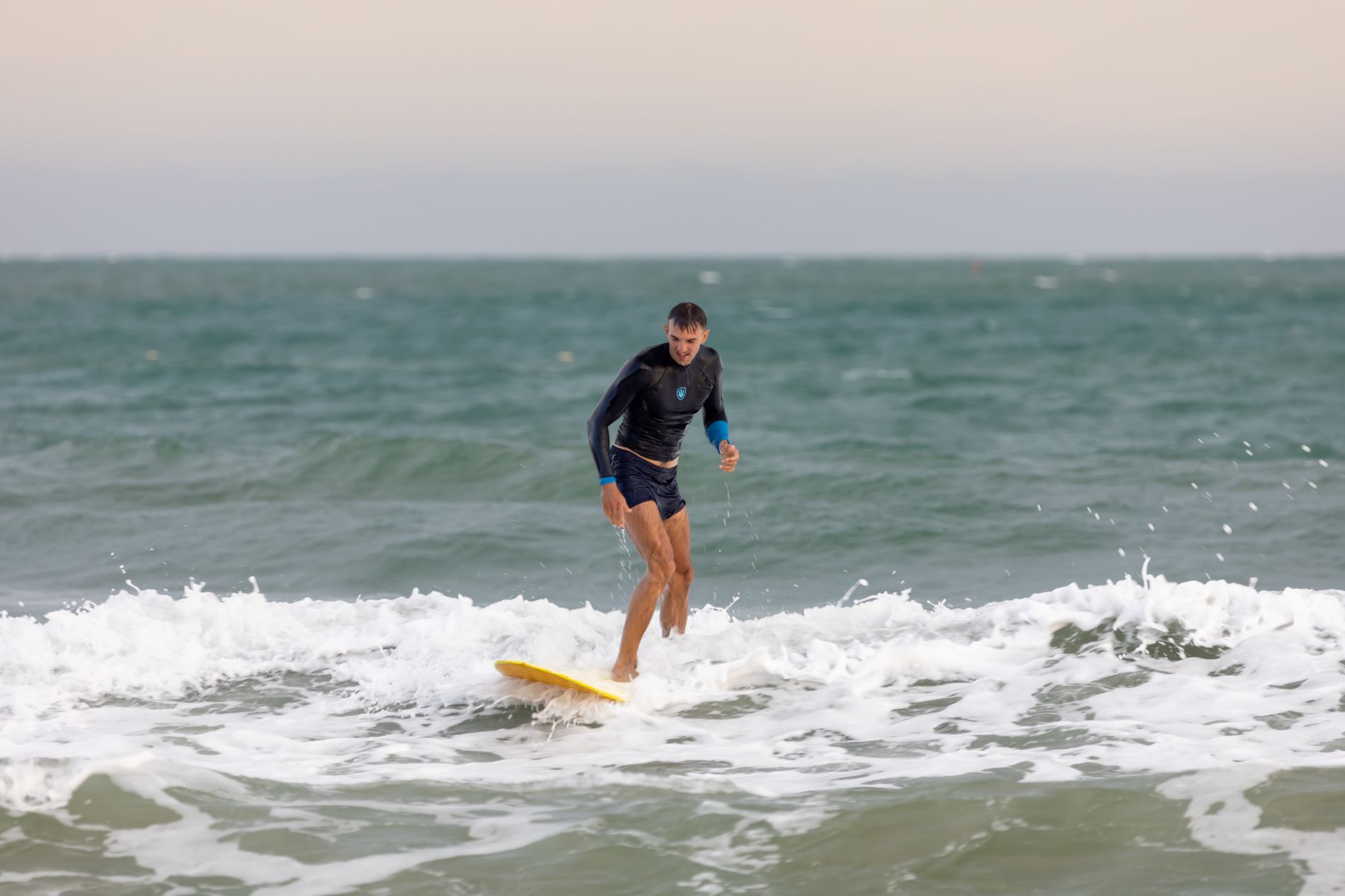 A surfer riding a wave on a bright day off the Atlantic coast