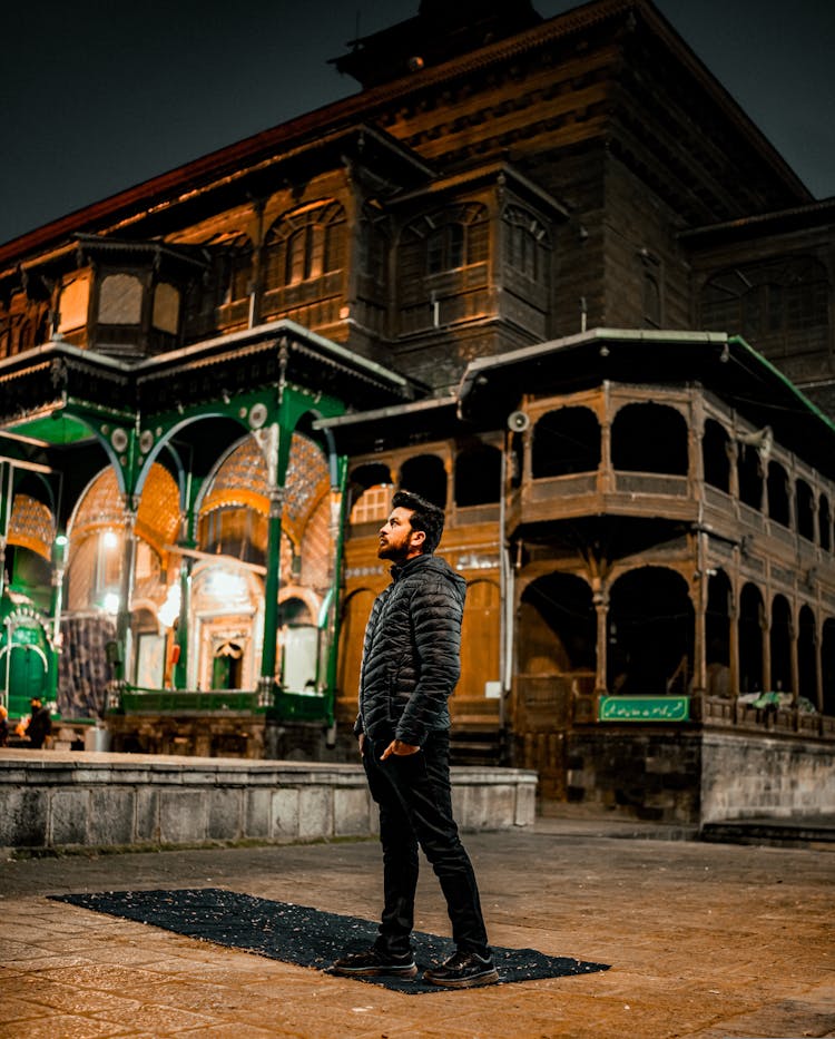 A Man In Black Jacket Standing Near An Shah E Hamdan R>H Mosque While Looking Afar