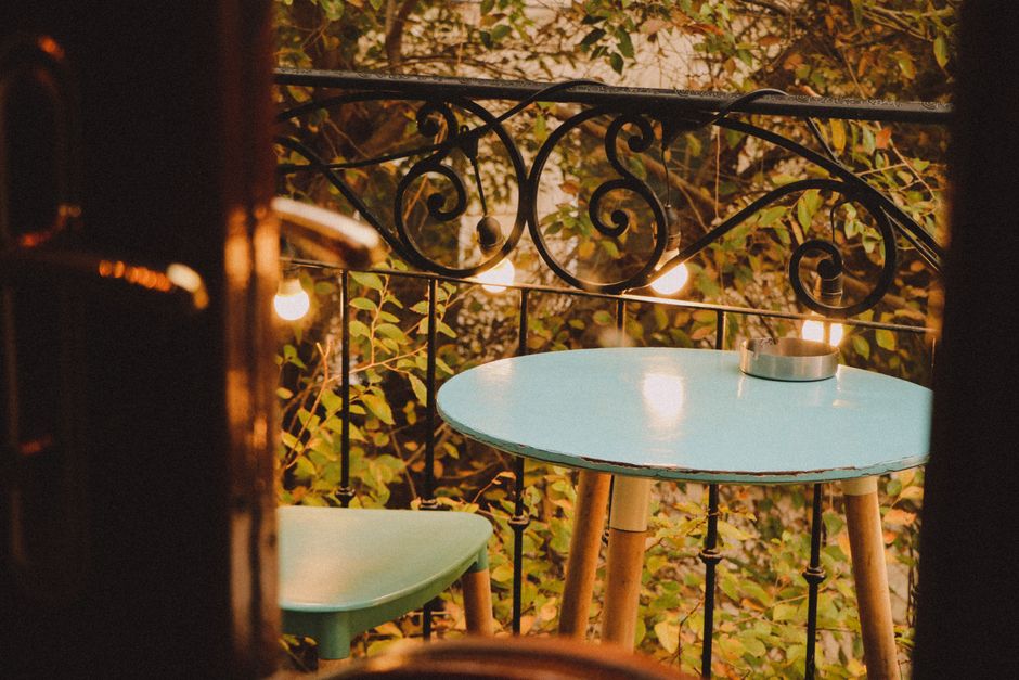 Abendlichter und Pflanzen auf kleinem Balkon mit gemütlicher Sitzgruppe