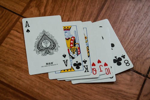 Seven Assorted Playing Cards on Brown Wooden Surface