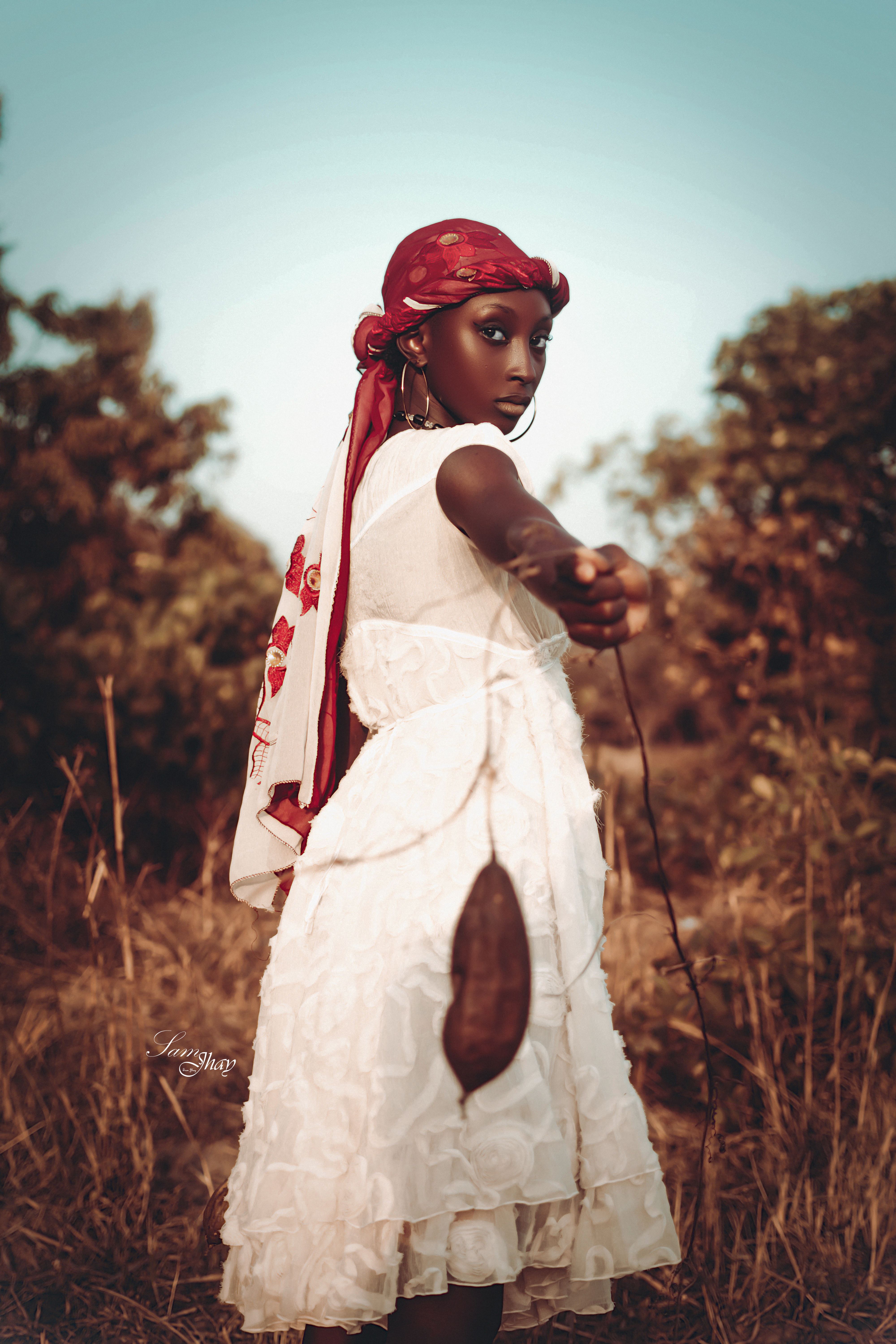 A stylish African woman posing elegantly outdoors, showcasing fashion and cultural attire.