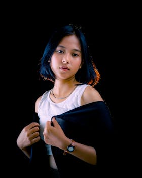 Studio portrait of a young Indonesian woman with short hair against a dark background.