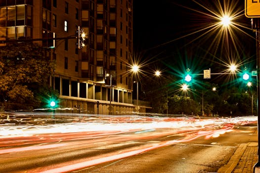 Long exposure shot of a city street at night, capturing vibrant light trails and urban ambiance.