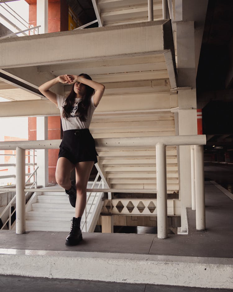 A Woman Posing By The Handrail