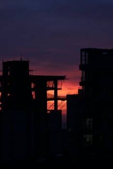 Silhouette of buildings against a vibrant sunset sky, capturing urban skyline.