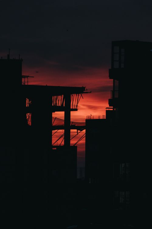 Free Dramatic cityscape silhouette at sunset with vibrant orange skies. Stock Photo