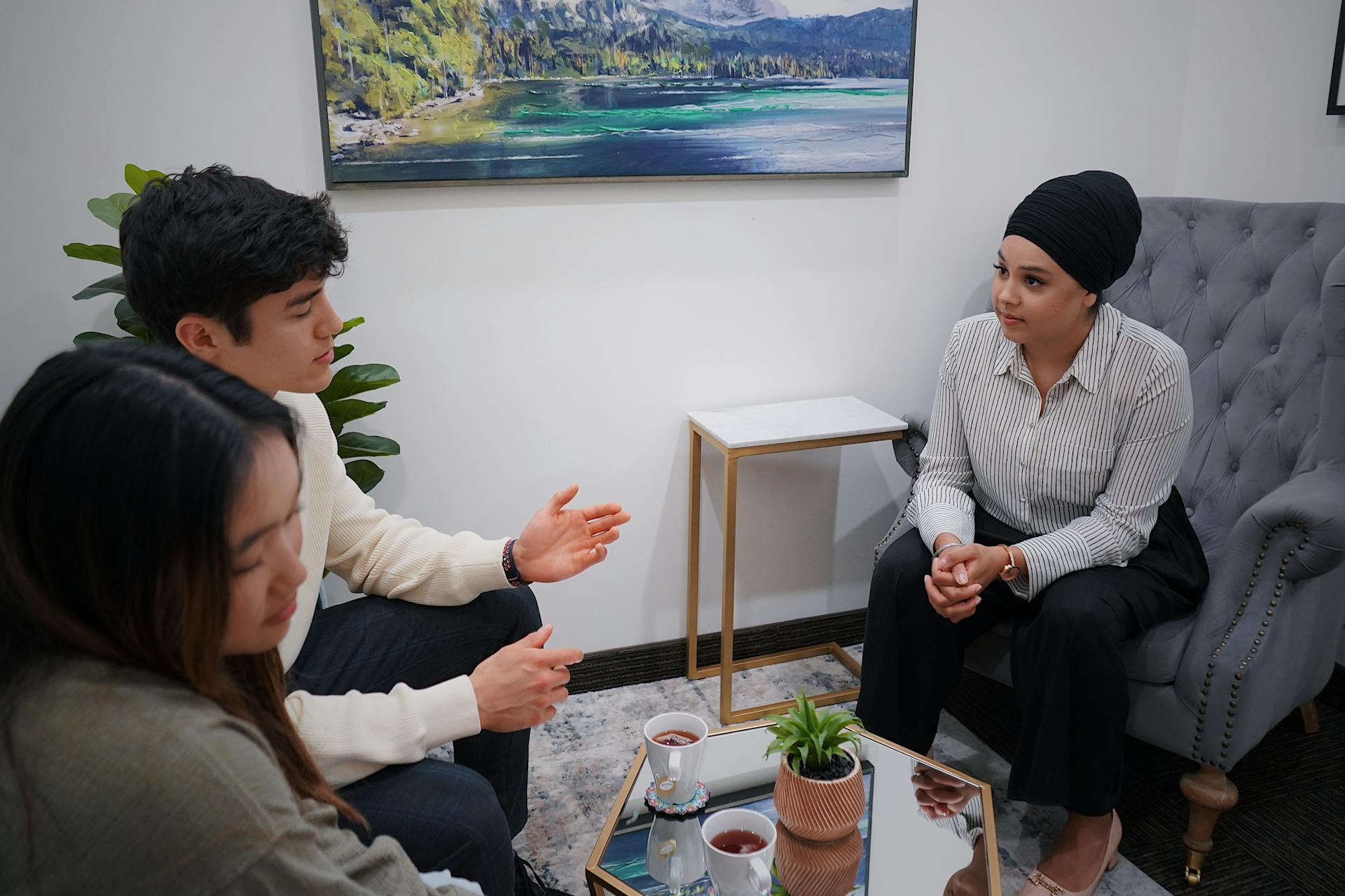 A couple in a therapy session discussing issues with a therapist in a modern office.