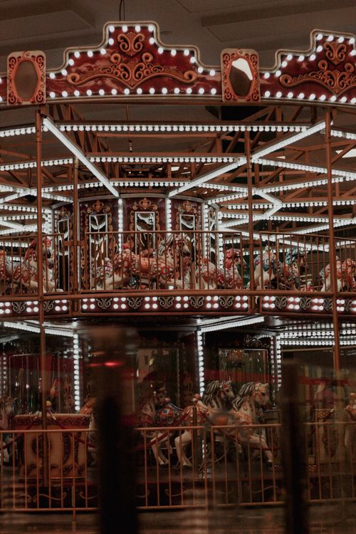 Free A vintage carousel glowing at night in an amusement park, evoking nostalgia and fun. Stock Photo