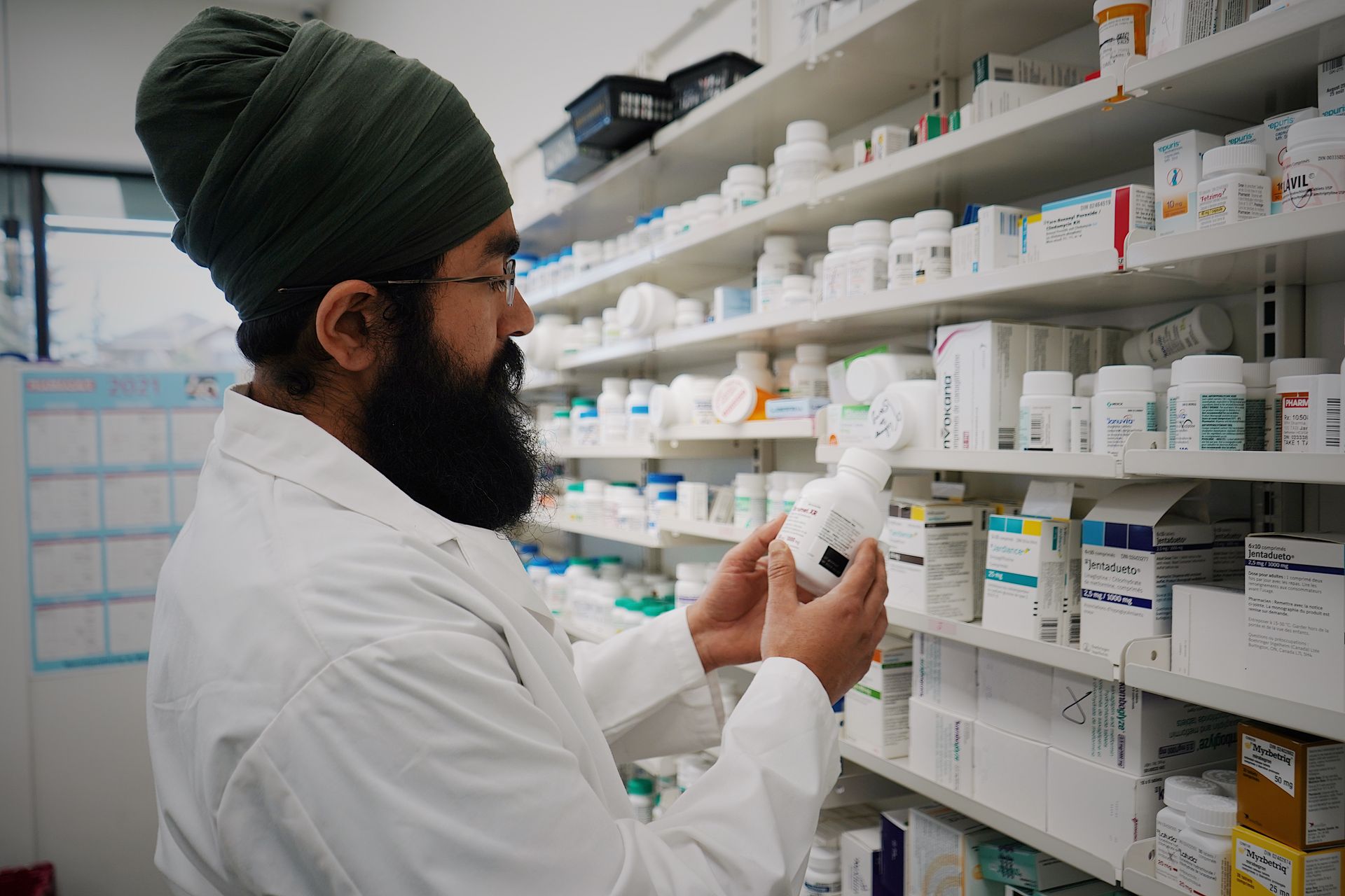 Filas de cajas de medicamentos en un estante de farmacia