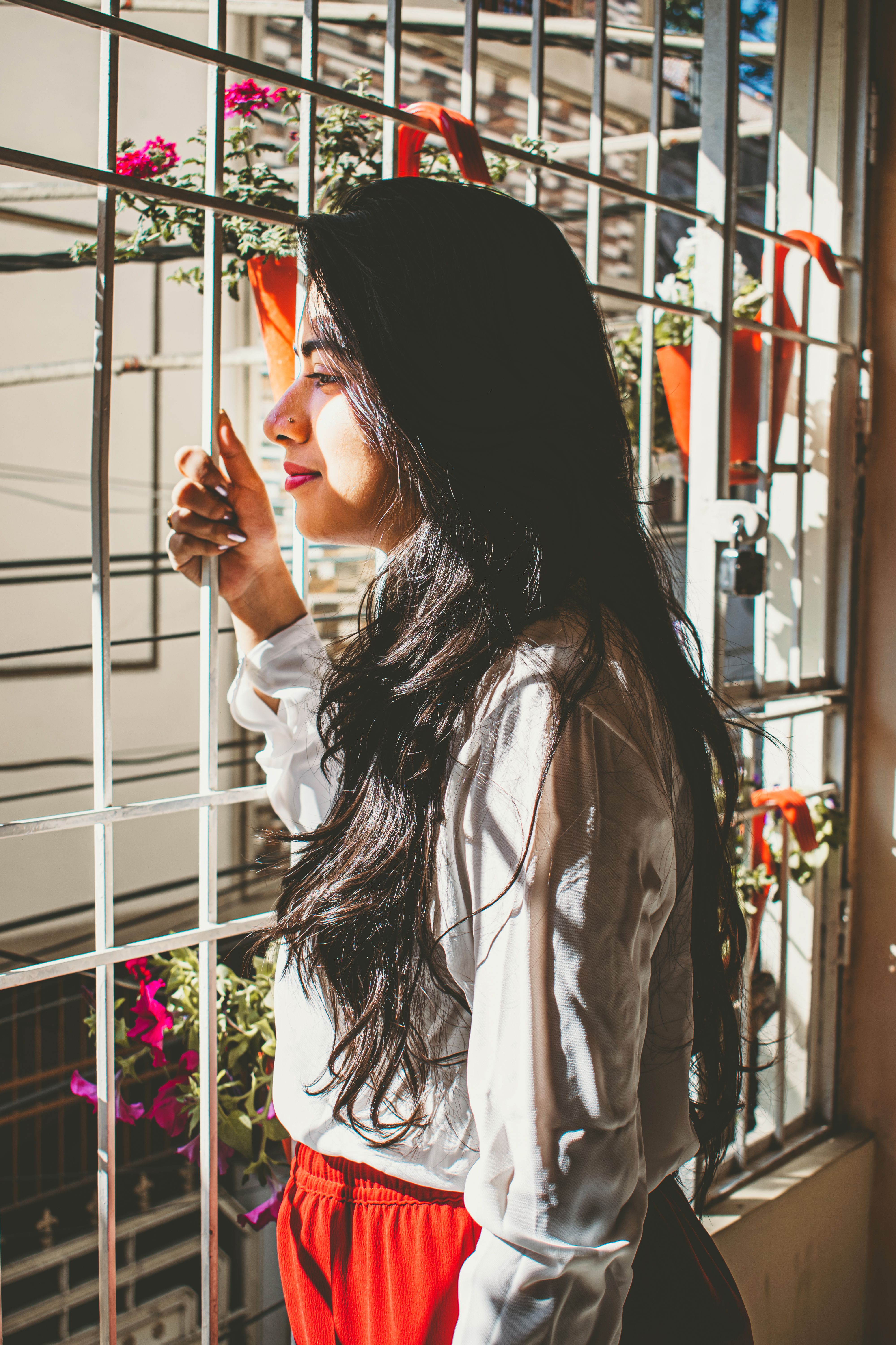 A Woman in White Long Sleeves Standing Near the Window · Free Stock Photo