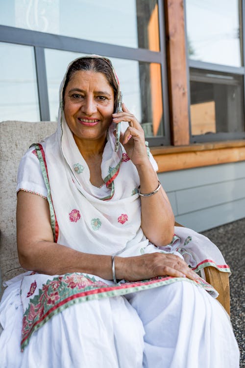 Photo of a Woman Talking on the Phone while Smiling