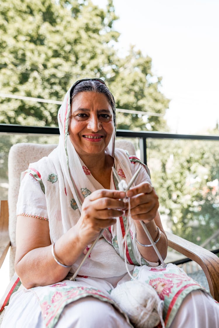 Woman Knitting On Balcony