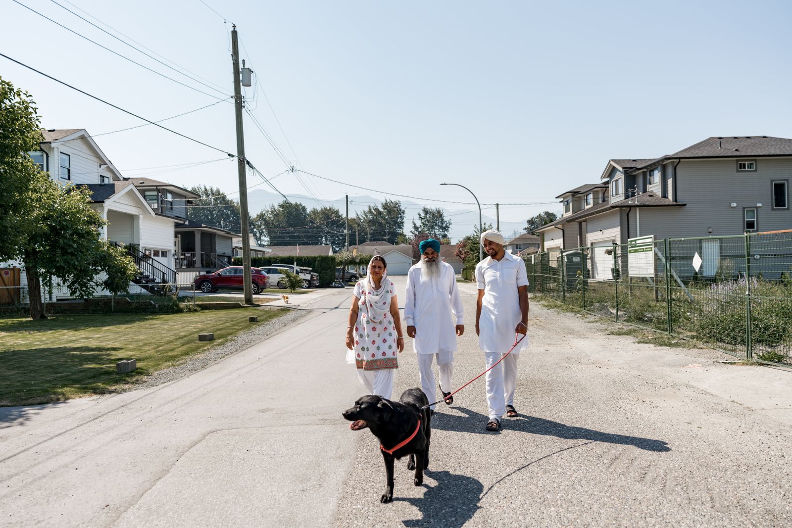 Several people walking outdoors with a dog