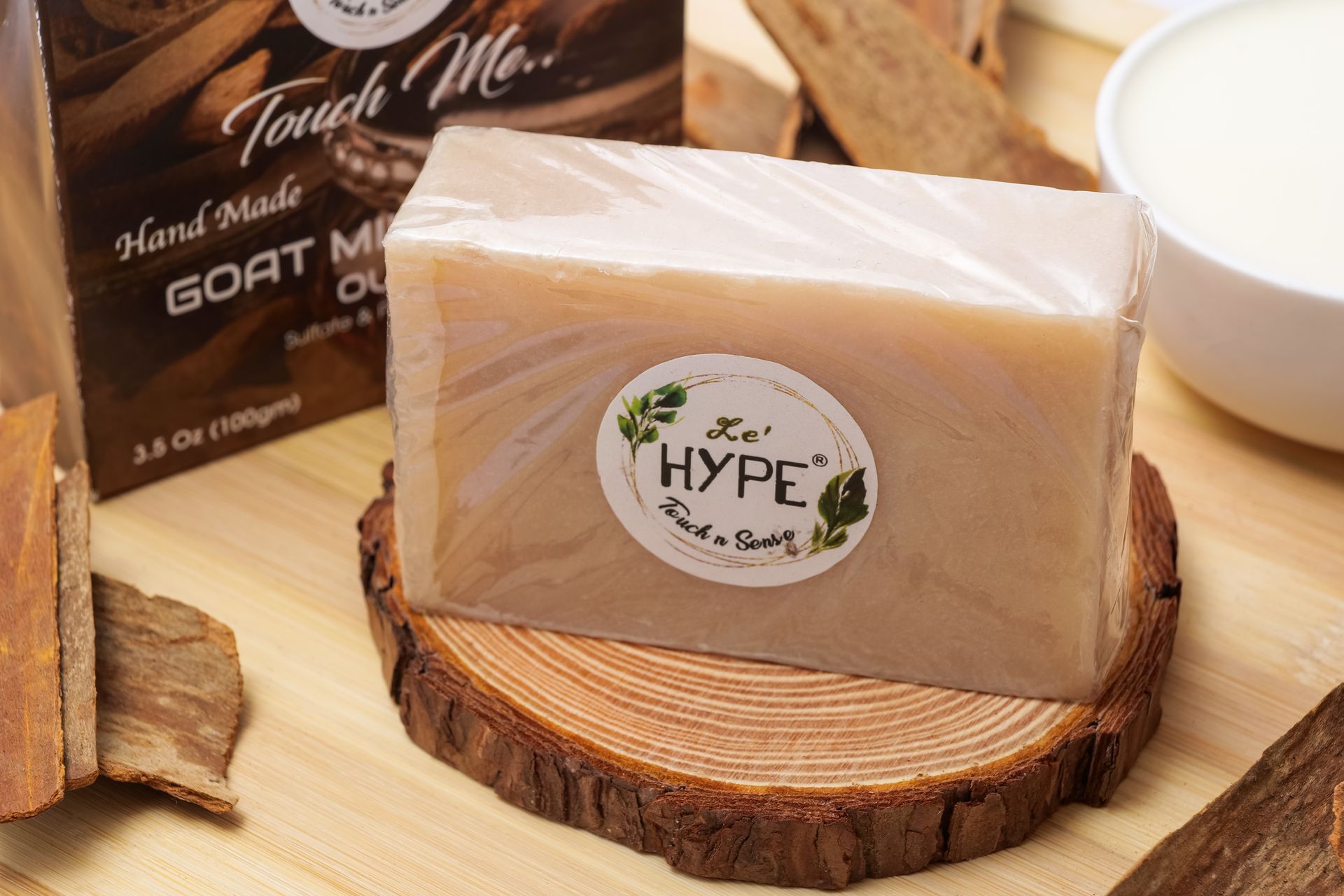 Close-up of handcrafted goat milk soap bar on a wooden slice, featuring natural ingredients and eco-friendly packaging.