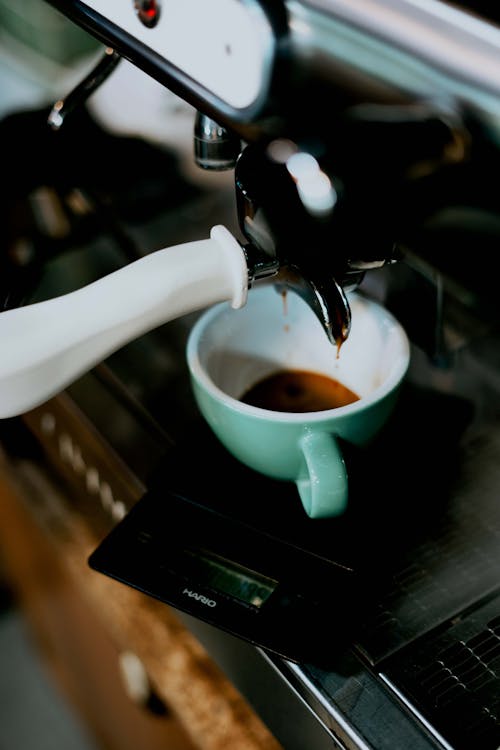 A Coffee Maker Machine and White Mug with Coffee