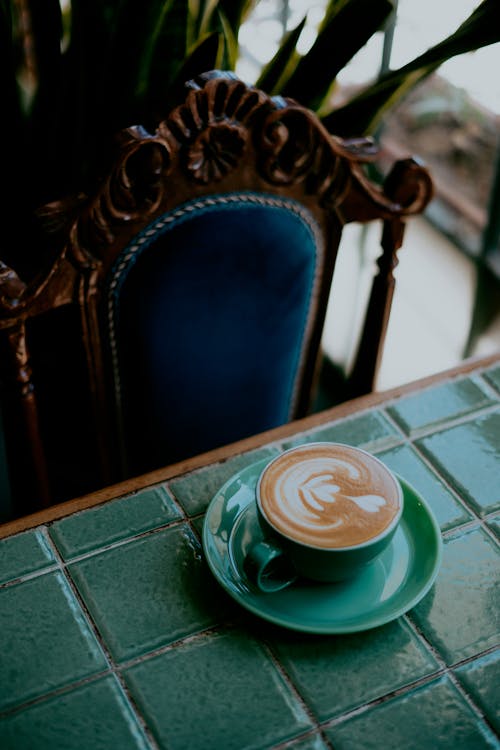 A Flat lay of Coffee on a Teal Ceramic Cup and Saucer