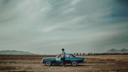 Man Standing Beside a Car