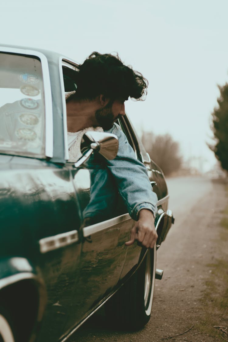 A Man Driving A Car 