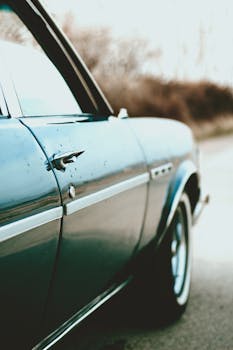 Close-up view of a vintage blue Buick Skylark with focus on the side, parked along a rural road.