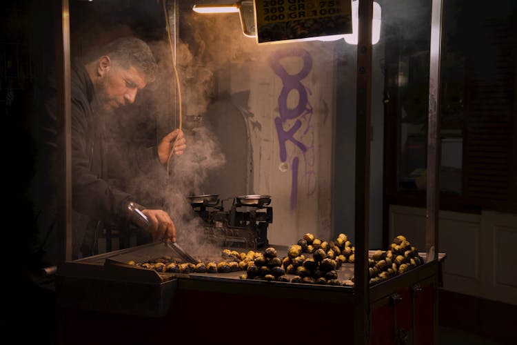 A Man Cooking At Night 