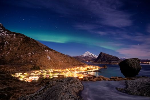 Stunning aurora borealis lights up the night sky over Napp in the Lofoten Islands, Norway.