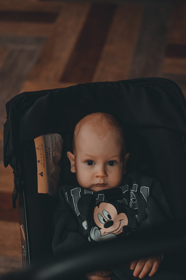 A Baby Sitting On The Stroller