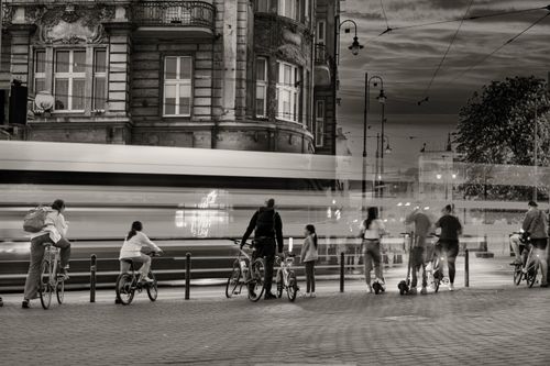Free Cyclists wait as blurred traffic passes by in a busy street in Bydgoszcz, Poland. Stock Photo
