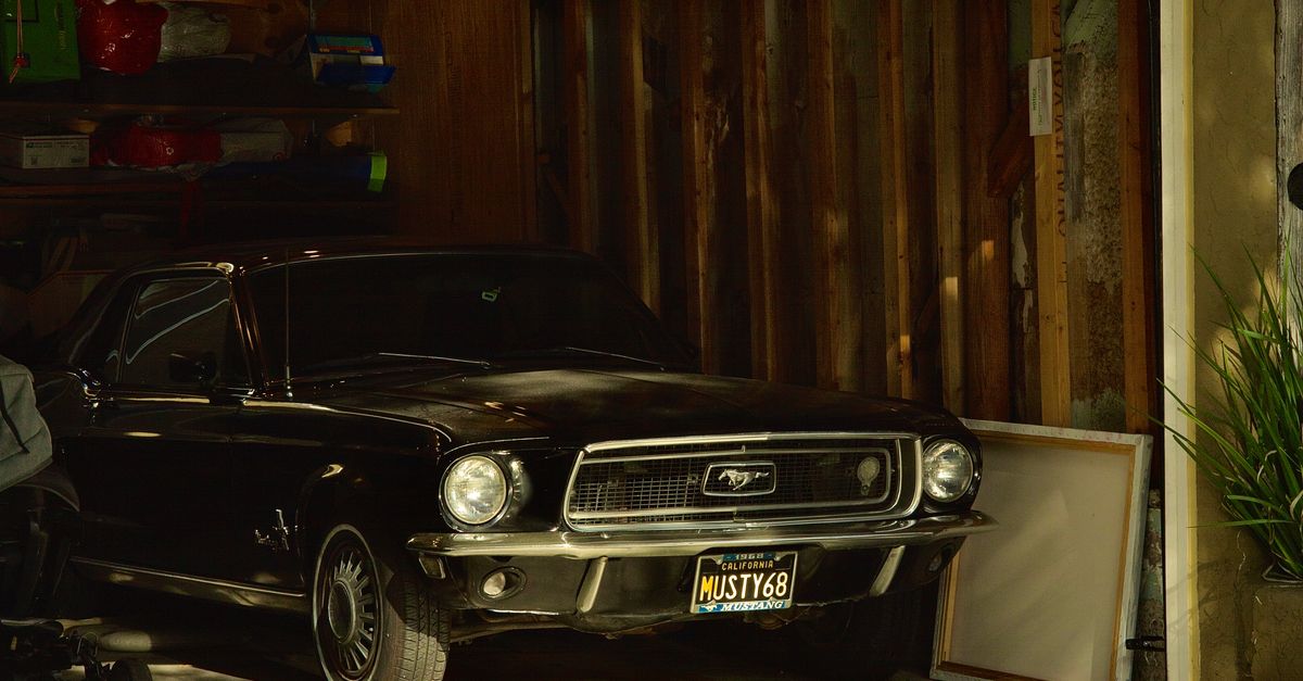 Classic 1968 Ford Mustang, black, parked in a garage, showcasing retro design.