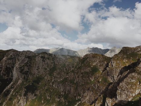 A stunning view of rugged rocky mountains under a cloudy sky, showcasing nature's majesty.