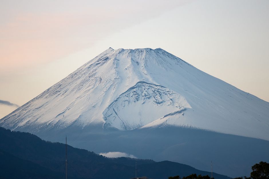 Serene view of Mount Fuji covered in snow under a calm sky, in Shizuoka, Japan.