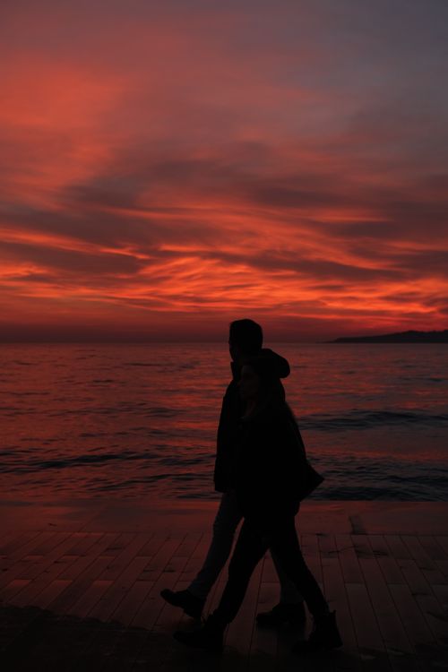 Free Ocean view at sunset with silhouettes of a couple strolling on the coast in Istanbul. Stock Photo