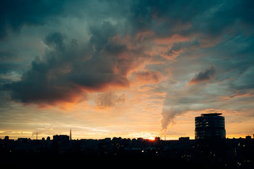 Silhouette of Saint Petersburg skyline with dramatic sunset clouds and smoke plumes.