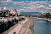 在日本京都一条风景优美的河畔小路上，人们悠闲地散步