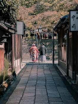 在日本京都的一条历史悠久的街道上，一对穿着和服的传统夫妇走过