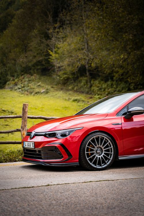 Free Stylish red Volkswagen Golf GTI parked on a scenic outdoor road. Stock Photo