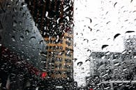 透过被雨水覆盖的窗户，可以看到上海戏剧性的城市景观