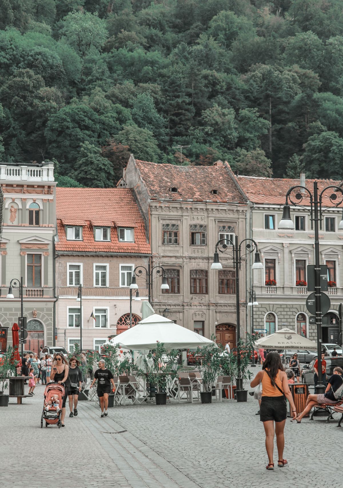 Brașov - oameni pe o stradă istorică, cu dealul Tâmpa în spate