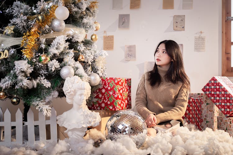 Woman Sitting Beside The Christmas Tree