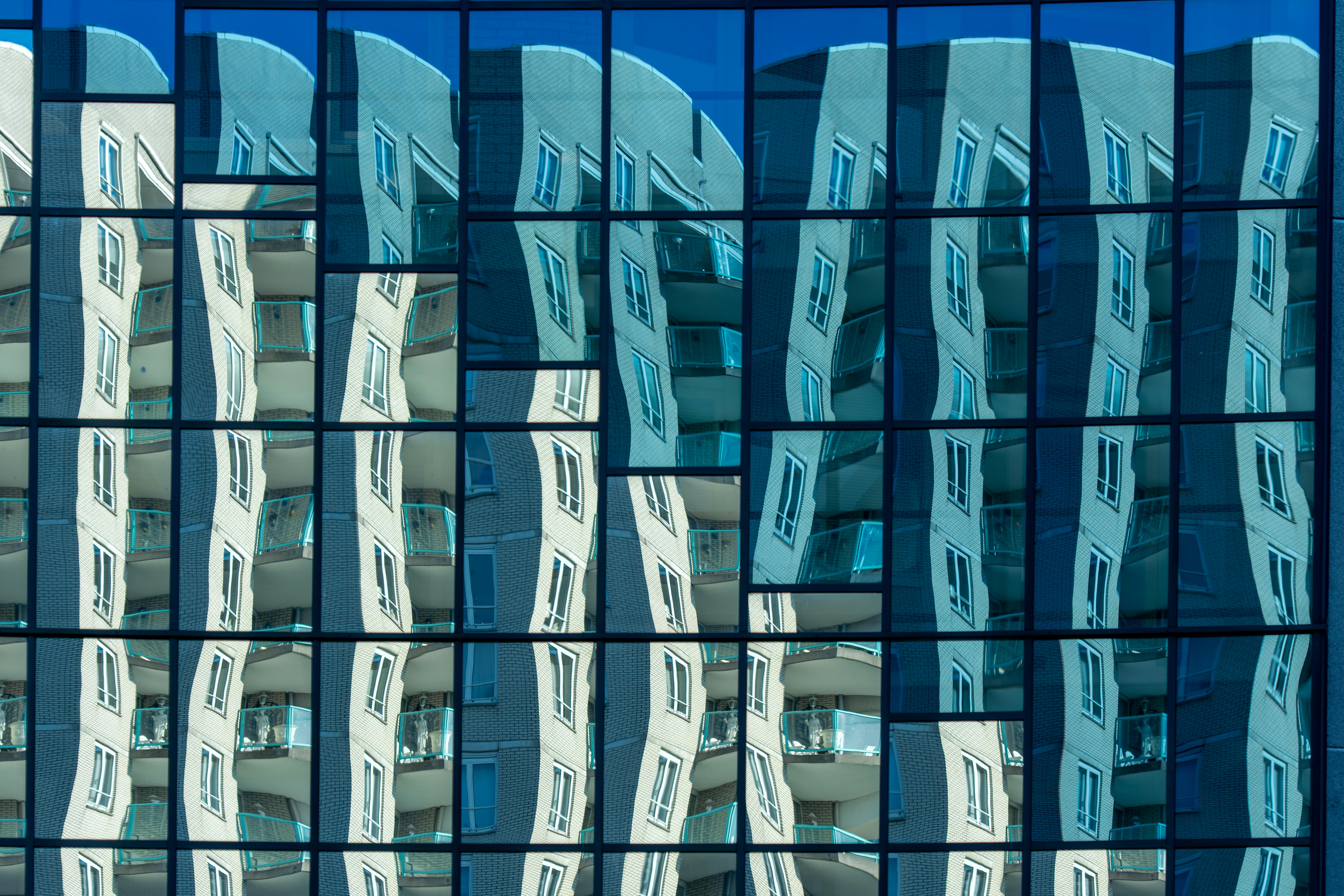Abstract reflection of architectural facade in glass windows, creating a unique urban perspective.