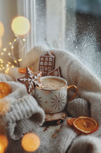 Warm coffee by the window with gingerbread and cozy decorations for Christmas.